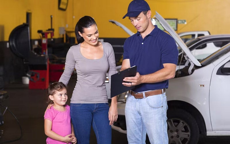 Technician with vehicle owner and child